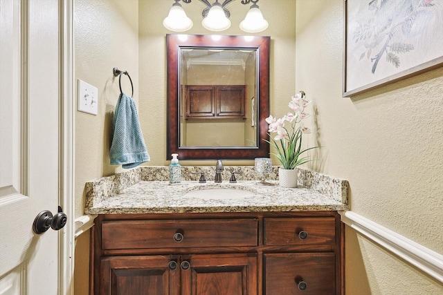 bathroom featuring a textured wall and vanity