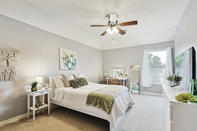 bedroom with light carpet, baseboards, a ceiling fan, and lofted ceiling