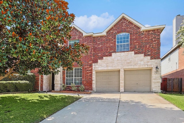 traditional-style home featuring brick siding, a front lawn, fence, concrete driveway, and stone siding