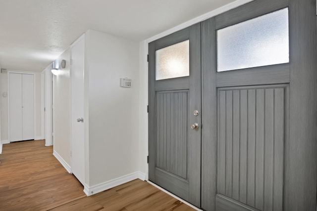 foyer with baseboards and wood finished floors