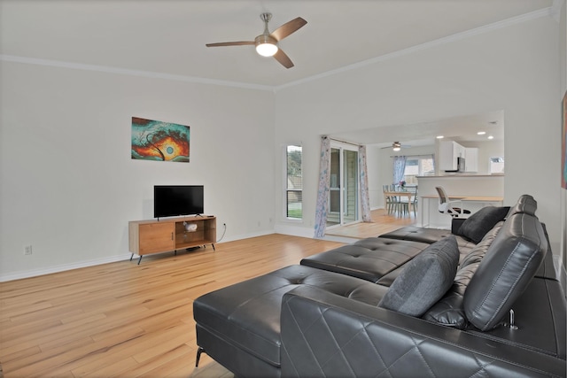 living area featuring baseboards, ceiling fan, wood finished floors, and crown molding