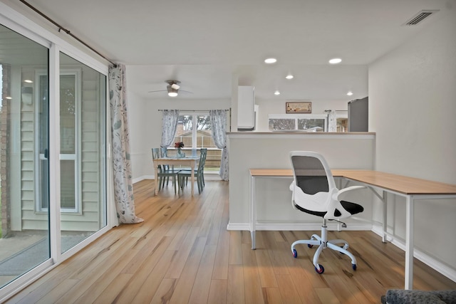 home office featuring light wood finished floors, baseboards, visible vents, and recessed lighting