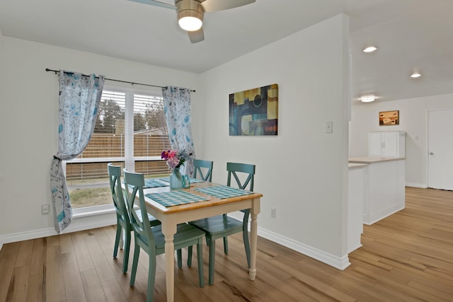 dining area with baseboards, ceiling fan, and light wood finished floors