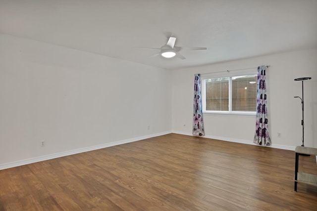 unfurnished room with a ceiling fan, baseboards, and wood finished floors