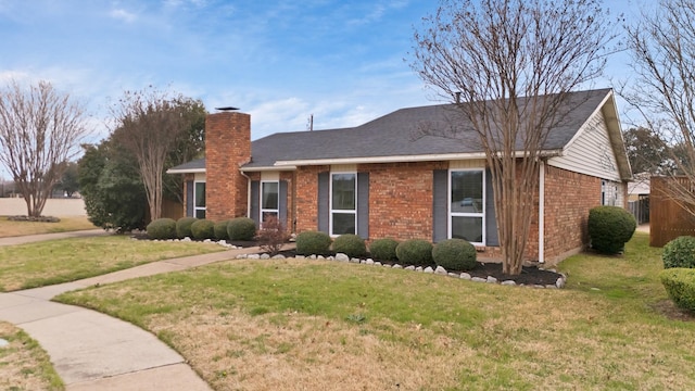 ranch-style home with a chimney, a front lawn, and brick siding