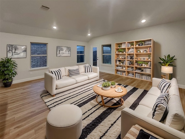 living area with light wood finished floors, visible vents, and recessed lighting