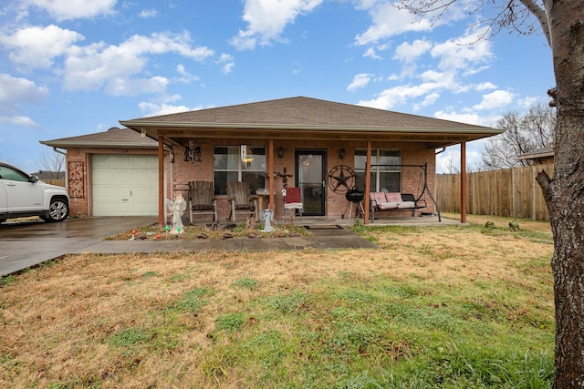 view of front of property featuring covered porch, a garage, fence, concrete driveway, and a front yard