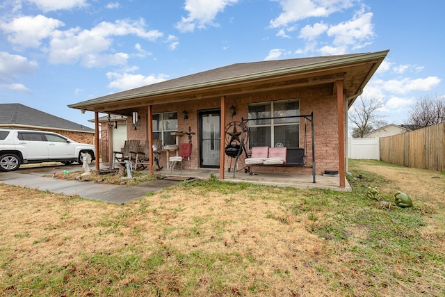 view of front facade featuring a patio area, fence, and a front lawn