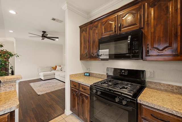 kitchen featuring black appliances, ornamental molding, light countertops, and visible vents