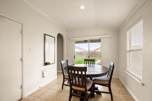 dining space featuring vaulted ceiling, light tile patterned floors, and crown molding