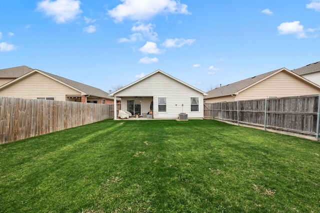 back of house featuring a fenced backyard, central AC unit, and a lawn