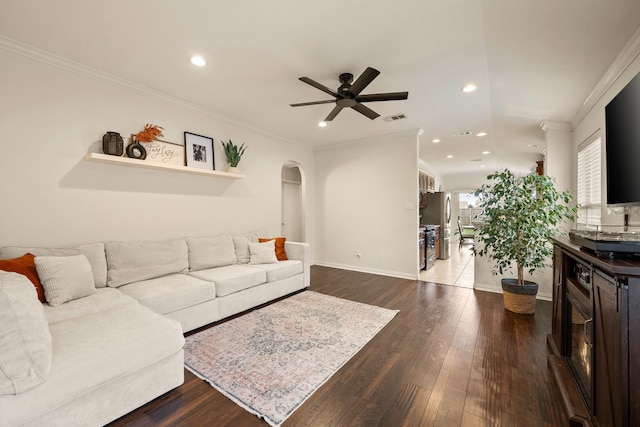 living room featuring visible vents, arched walkways, wood finished floors, crown molding, and recessed lighting