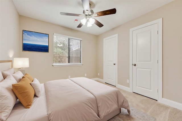 bedroom featuring baseboards, a ceiling fan, and light colored carpet