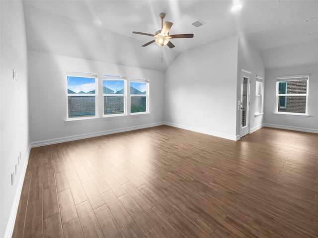 interior space with a ceiling fan, vaulted ceiling, visible vents, and dark wood finished floors