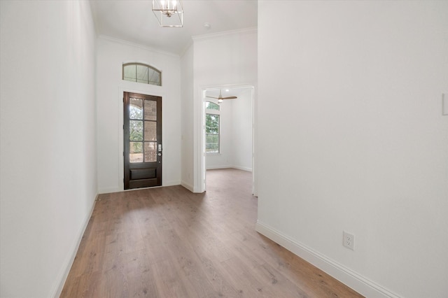 entrance foyer with light wood-type flooring, an inviting chandelier, and baseboards