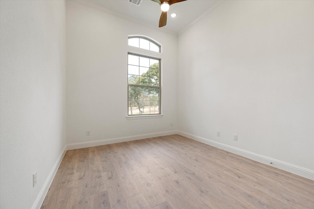 empty room featuring ceiling fan, plenty of natural light, light wood-style flooring, and baseboards