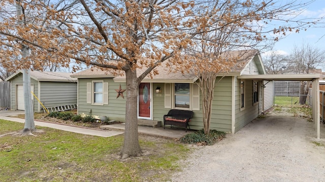 view of front facade featuring a carport, roof with shingles, fence, and driveway