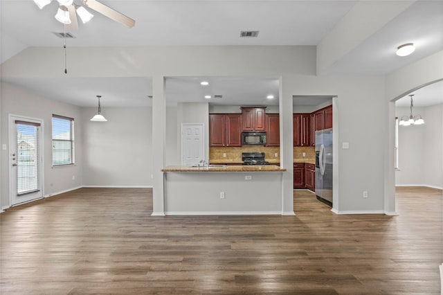 kitchen with arched walkways, black appliances, open floor plan, and visible vents