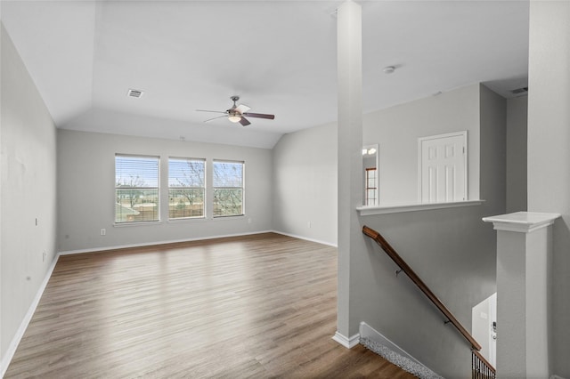 unfurnished living room with vaulted ceiling, ceiling fan, wood finished floors, and baseboards