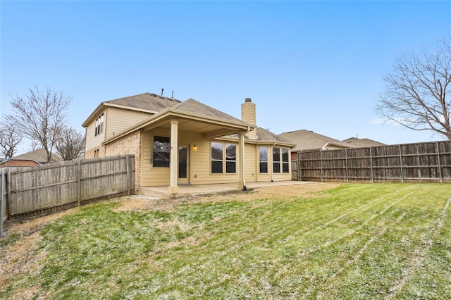 rear view of property featuring a patio area, a fenced backyard, a lawn, and a chimney