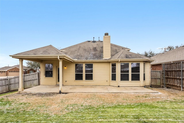 back of house featuring a lawn, a patio area, and a fenced backyard