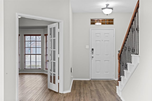 entryway featuring baseboards, stairway, and wood finished floors