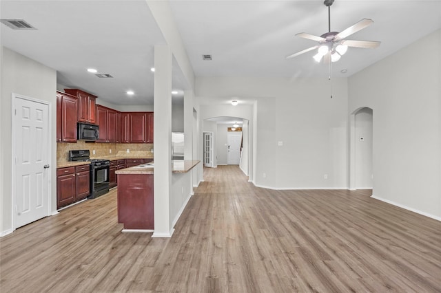 kitchen featuring black appliances, arched walkways, and open floor plan