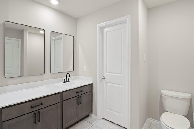 bathroom featuring baseboards, vanity, toilet, and tile patterned floors