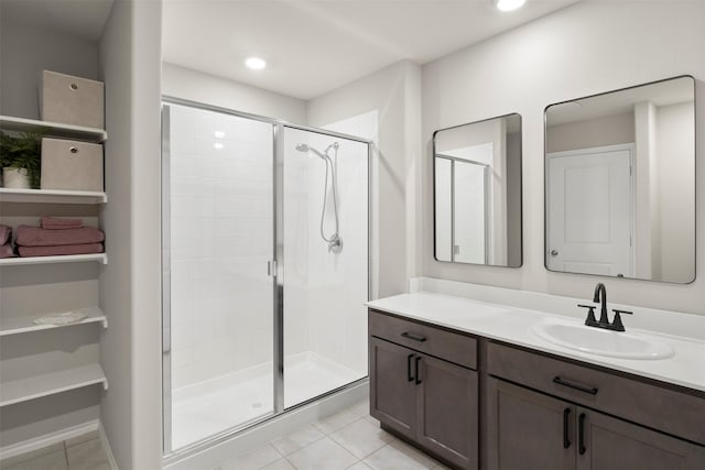 bathroom with a closet, a shower stall, vanity, and tile patterned floors