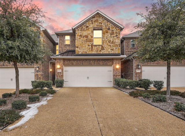 view of front of house featuring driveway, brick siding, and stone siding