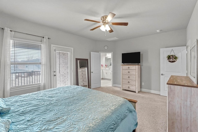 bedroom with baseboards, ensuite bathroom, a ceiling fan, and light colored carpet