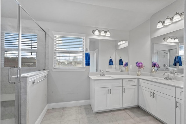 full bath featuring a sink, a shower stall, baseboards, and double vanity