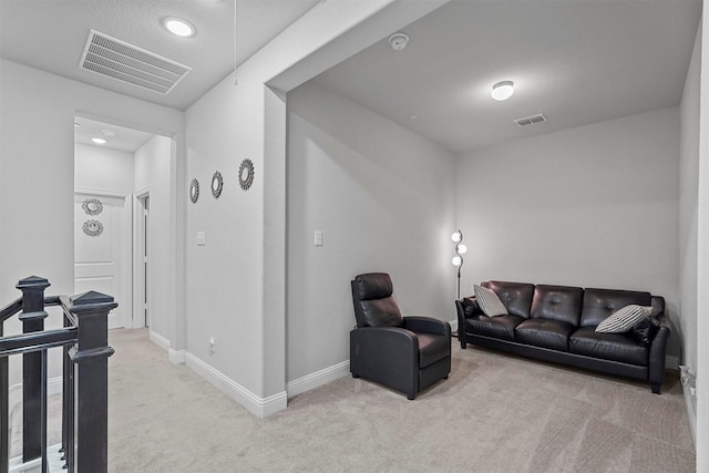 living room featuring baseboards, visible vents, and light colored carpet