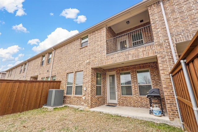 rear view of property with brick siding, a patio, and central air condition unit