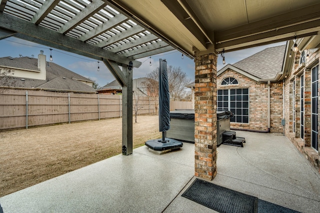 view of patio / terrace with a hot tub, a fenced backyard, and a pergola