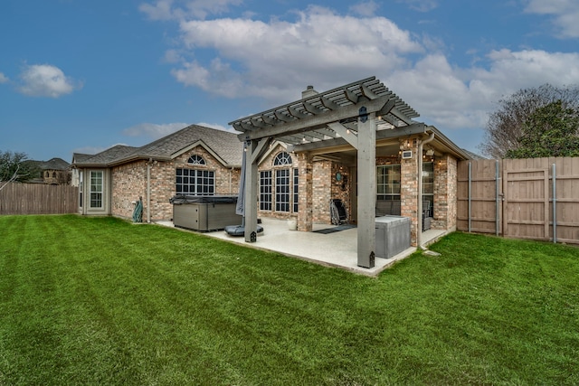 rear view of property featuring a hot tub, a lawn, a patio area, a pergola, and brick siding