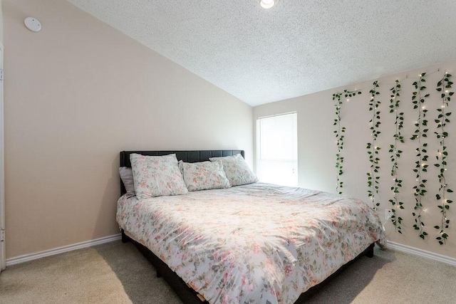 carpeted bedroom with baseboards, vaulted ceiling, and a textured ceiling