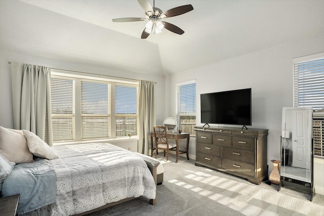 bedroom with a ceiling fan, light colored carpet, vaulted ceiling, and baseboards