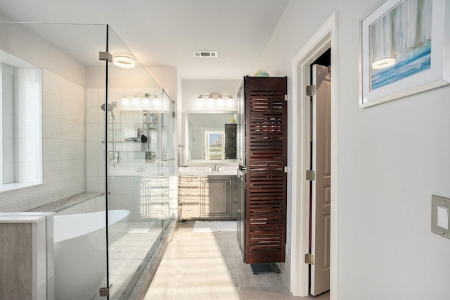 full bathroom featuring visible vents, a freestanding bath, a shower stall, and vanity