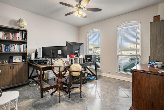 office area featuring ceiling fan and baseboards