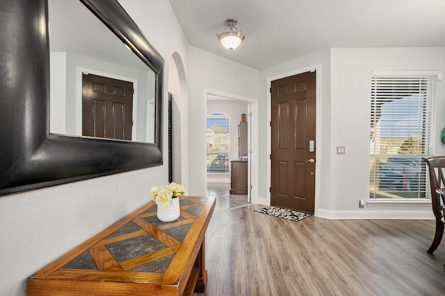 foyer entrance with wood finished floors and baseboards