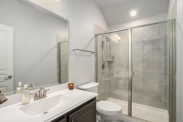 full bathroom with a textured wall, a stall shower, vanity, and toilet