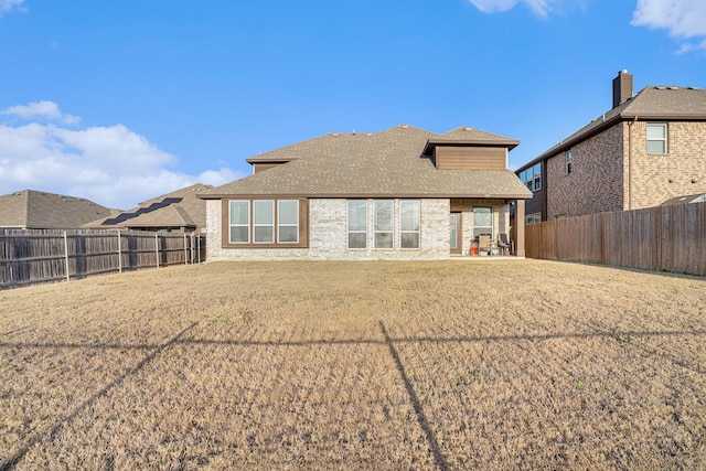 back of house featuring a fenced backyard, a shingled roof, a patio, and a yard