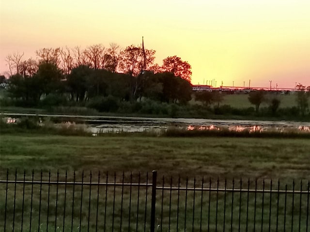 exterior space with a water view and fence