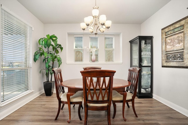 dining room featuring an inviting chandelier, wood finished floors, and baseboards