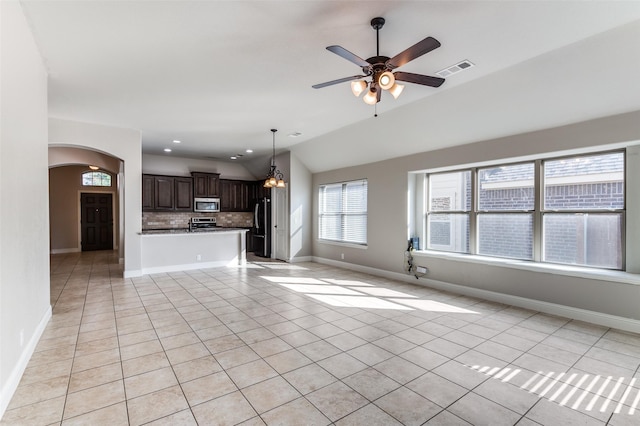 unfurnished living room featuring arched walkways, ceiling fan, light tile patterned flooring, and recessed lighting