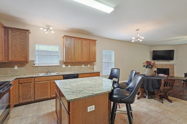 kitchen featuring tasteful backsplash, a kitchen island, hanging light fixtures, black appliances, and a chandelier