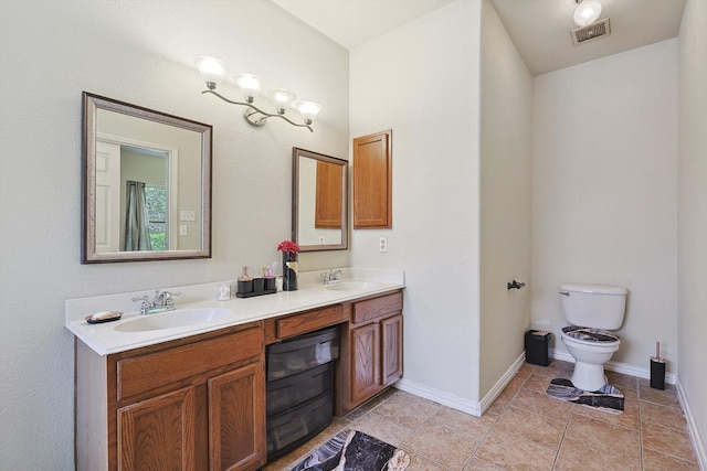 bathroom featuring double vanity, a sink, visible vents, and baseboards