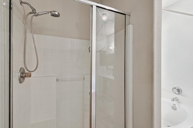 bathroom with a stall shower and a bath