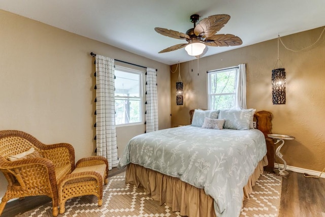 bedroom with a ceiling fan, baseboards, and wood finished floors